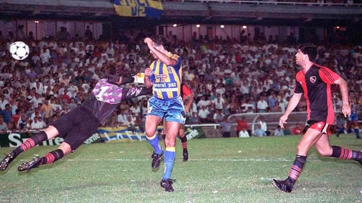 Jugador de Rosario Central definiendo ante la estirada del arquero de Newell's, foto de los años noventa