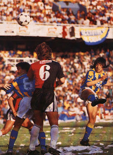 Jugador de Rosario Central definiendo de cabeza dentro del área de Newell's, foto de los años noventa