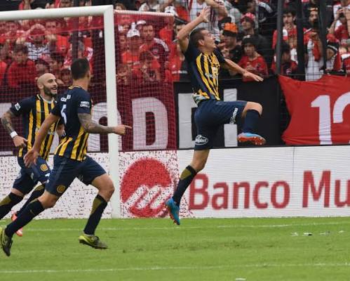 Dos jugadores de Rosario Central festejando un gol juntos, camiseta con sponsor Banco Municipal
