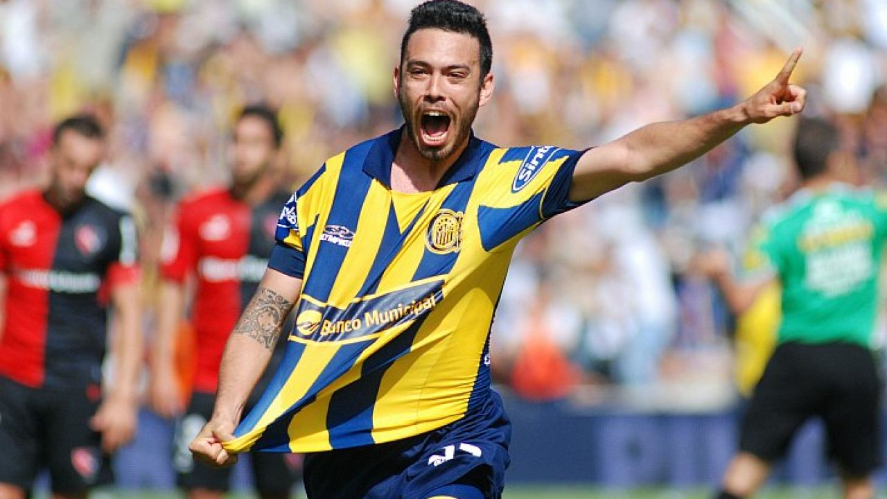 Jugador de Rosario Central festejando un gol con el puño en alto ante jugadores de Newell's