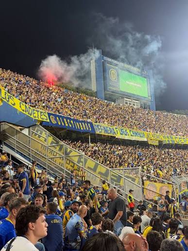 Ambiente nocturno en las tribunas del Gigante de Arroyito con la pantalla gigante encendida