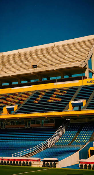 Detalle arquitectónico de las tribunas vacías del Gigante de Arroyito, con butacas azules y amarillas