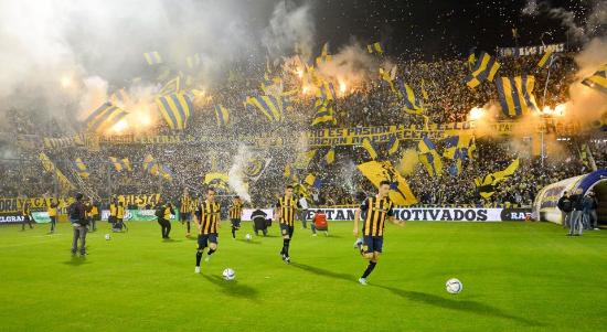 Jugadores de Rosario Central ingresando a la cancha entre banderas y bengalas
